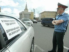 Милиционер у машины. Фото с сайта kommersant.ru