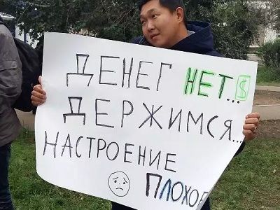 Активист с плакатом "Денег нет. Держимся. Настроение плохое". Фото: Аригус