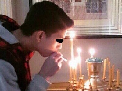 Подросток прикурвает от свечи в храме