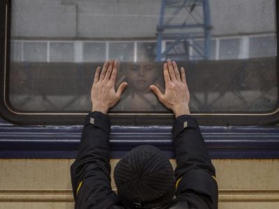 Александр, 41 год, прижимает ладони к окну, прощаясь со своей дочерью Анной, 5 лет, в поезде во Львов на Киевском вокзале, Украина, пятница, 4 марта. 2022. Фото: Emilio Morenatti /AP Photo