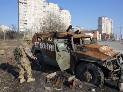 Украинский солдат осматривает подбитый российский бронетранспортер в Харькове. Фото: Efrem Lukatsky / AP /