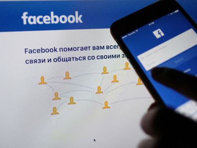 Страница социальной сети "Фейсбук" на экранах компьютера и смартфона. Фото: Наталья Селиверстова / РИА Новости