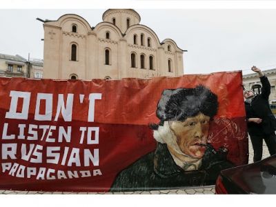Активист держит плакат с портретом голландского художника Винсента Ван Гога c надписью "Don't listen to Russian propaganda" (не слушайте российскую пропаганду) во время демонстрации перед посольством Нидерландов в Киеве, Украина, 5 февраля 2