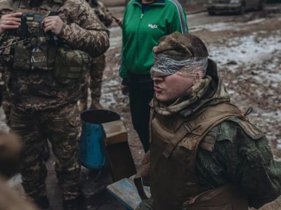 Украинские военные обыскивают пленного солдата армии РФ. Фото: Diego Herrera Carcedo / Anadolu Agency